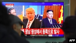 FILE - People stop to watch a television news screen showing pictures of U.S. President Donald Trump and North Korean leader Kim Jong Un at a railway station in Seoul, South Korea, Nov. 29, 2017.