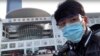 中国公民记者陈秋实在中国中部湖北省武汉市一场病毒性疫情中，在一家会议中心改建的临时医院前面。(2020年2月4日)