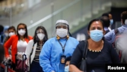 Viajeros con mascarillas protectoras durante la reapertura del Aeropuerto Internacional Mons. Oscar Arnulfo Romero de El Salvador el 19 de septiembre de 2020.