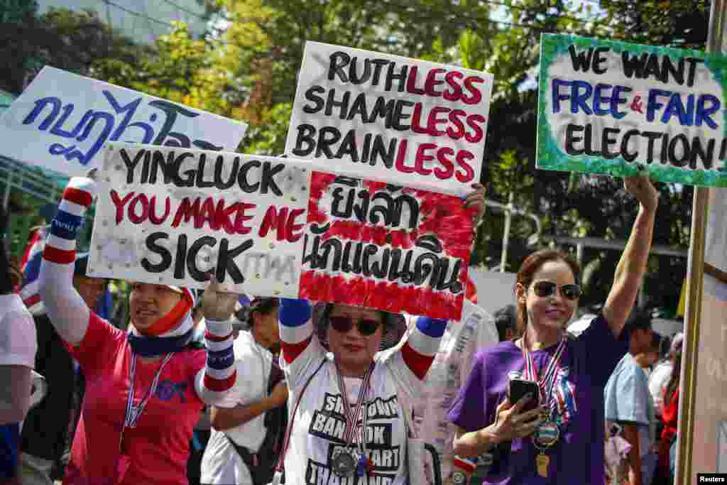 Anti-government protesters hold placards during a march through central Bangkok, Jan. 30, 2014.